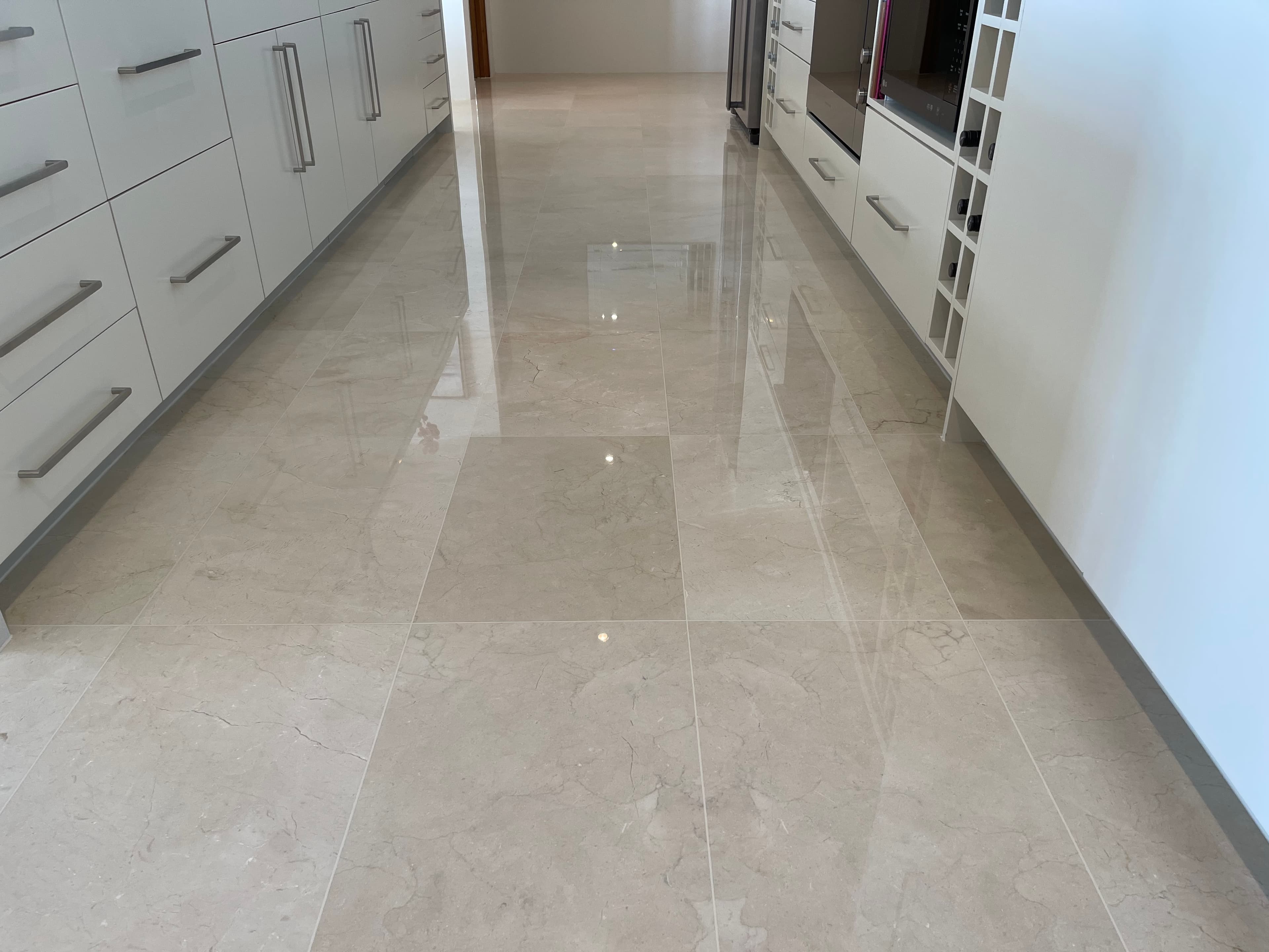 The same natural stone floor after polishing, with an even reflective finish