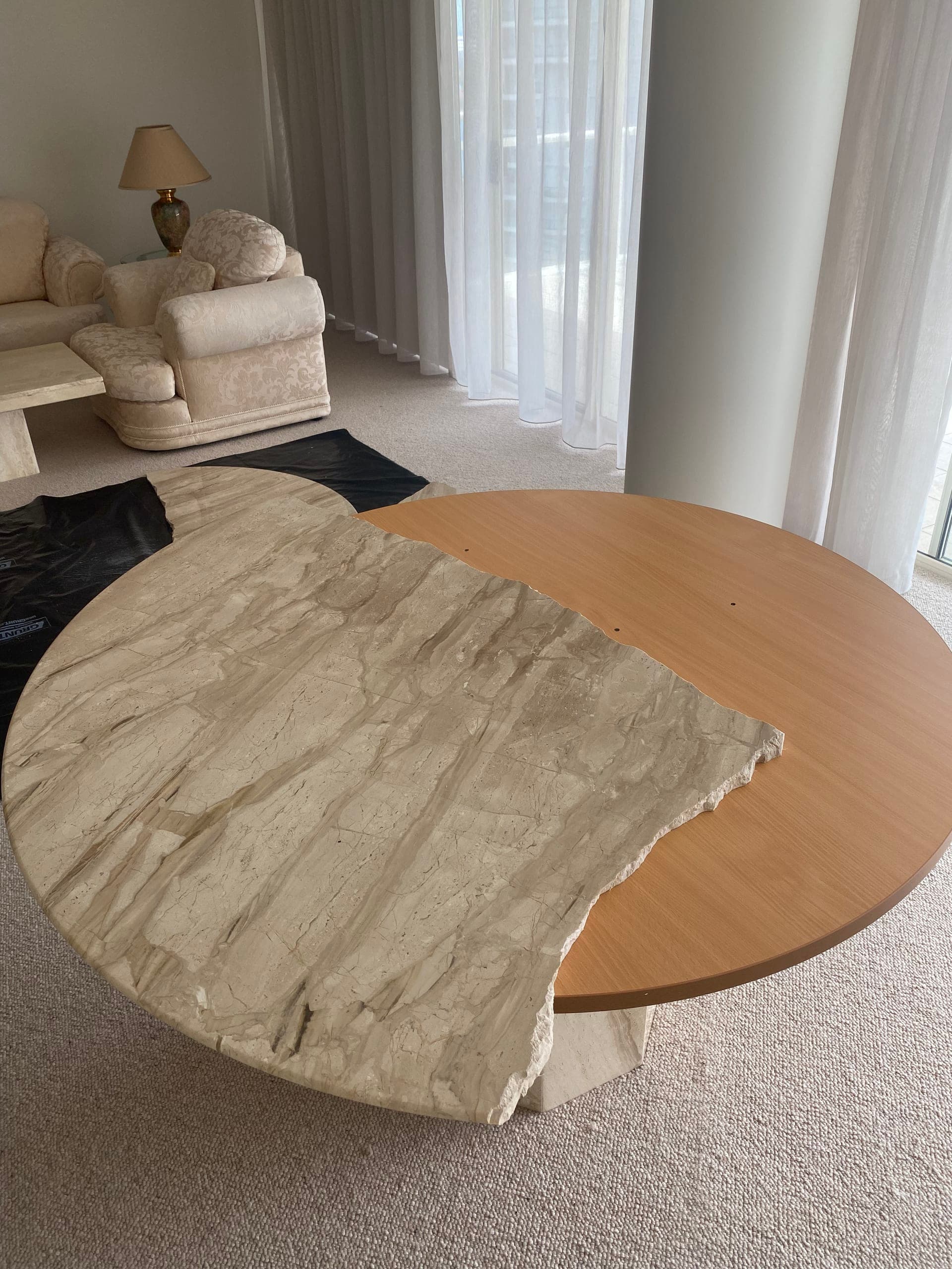 Broken half of the natural stone top resting on top of the round timber top