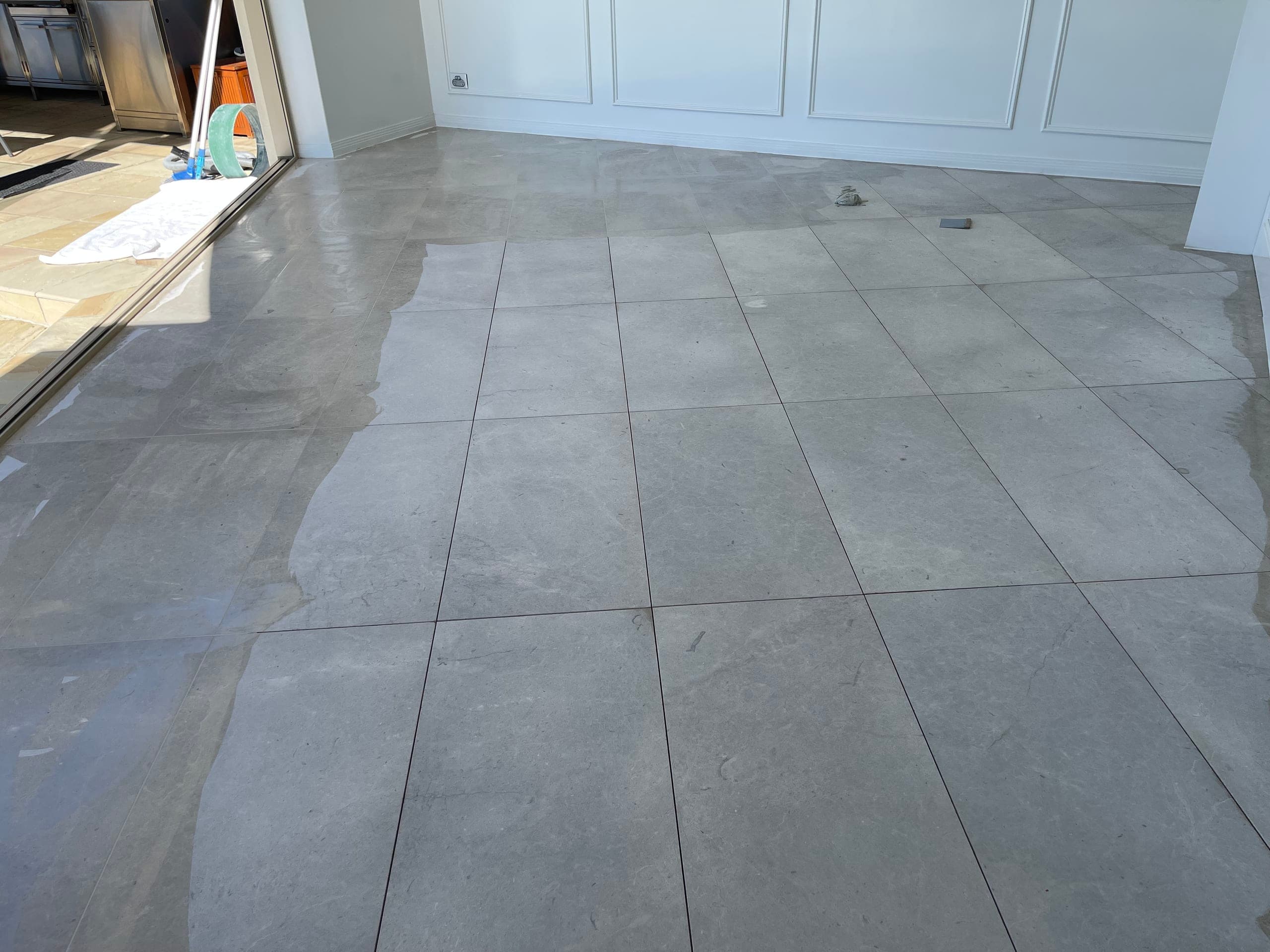 Tile joints being filled on the dining-area marble floor