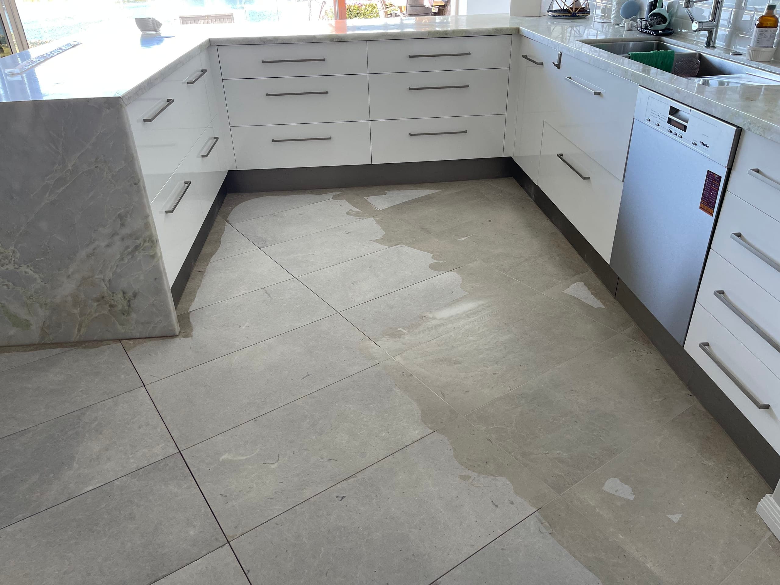 Kitchen marble floor being ground with its tile joints filled