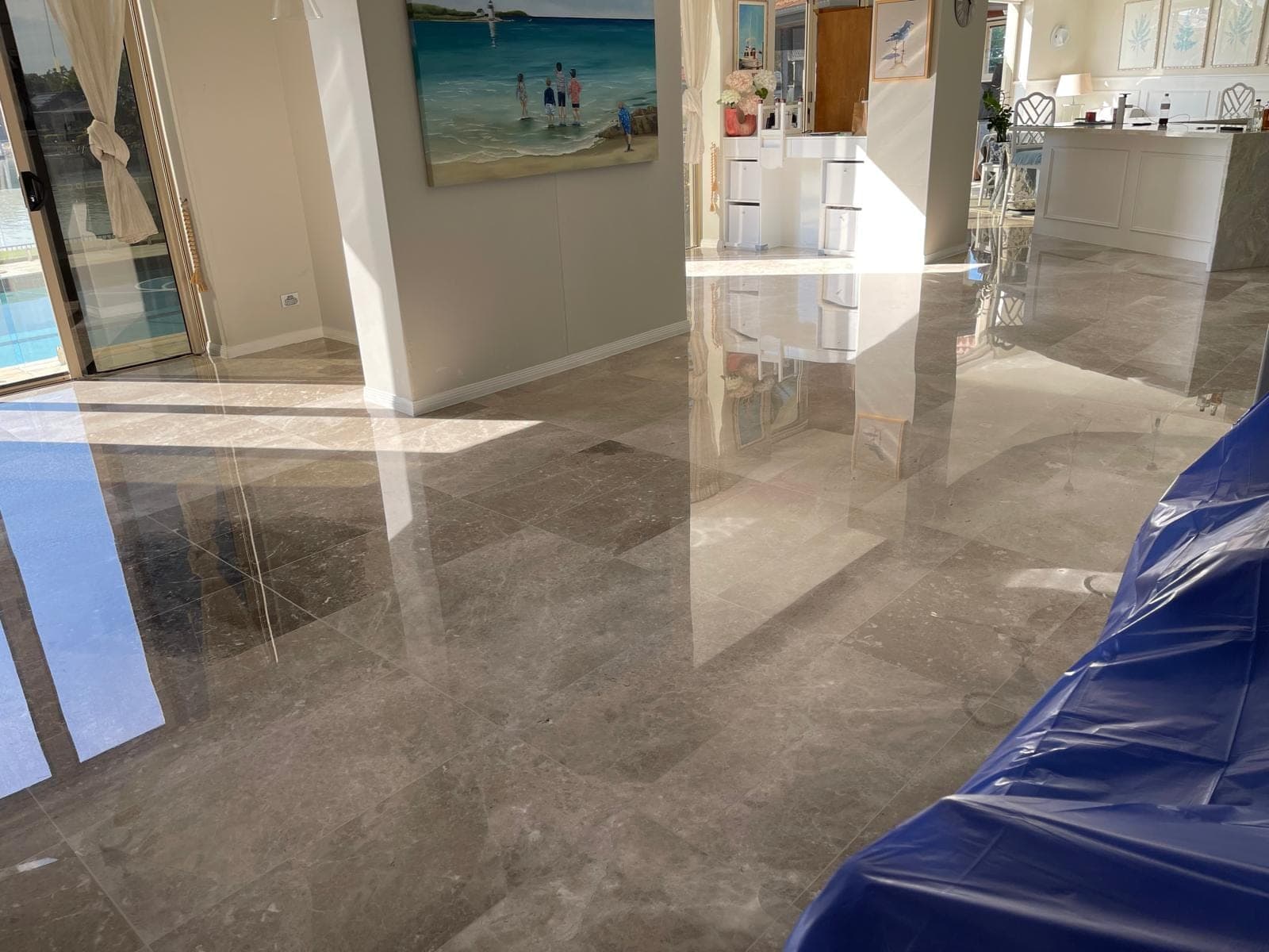 Polished grey marble living-area floor reflecting the room after restoration