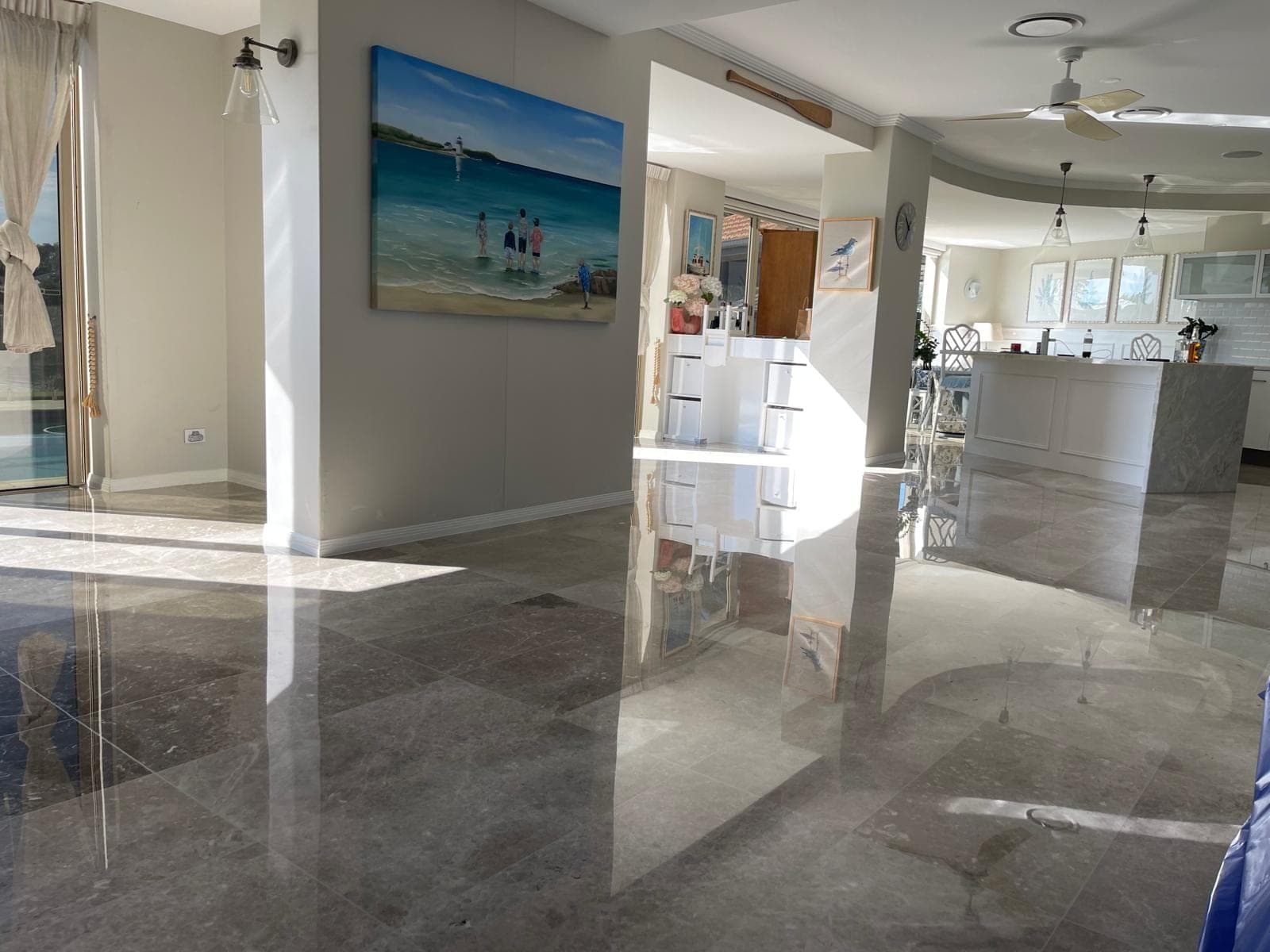 High-gloss marble floor mirroring a chair and window light after polishing