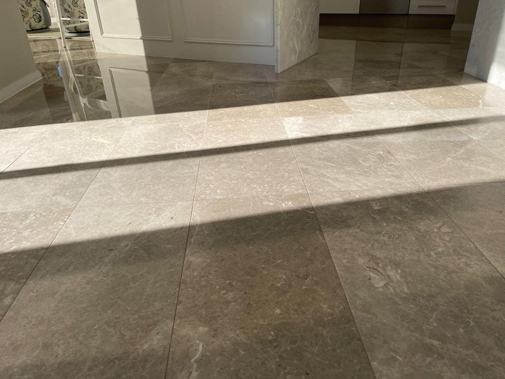 Worn grey marble floor in the open-plan living area, flat and light-scattering before grinding