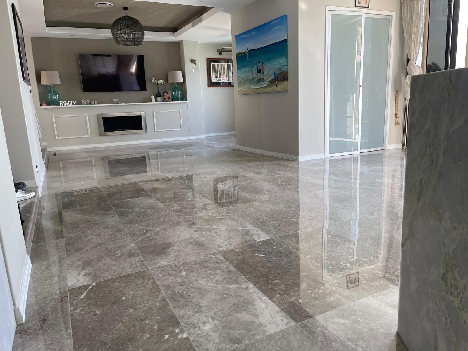 Polished marble floor in the furnished living area, with artwork reflected in the surface