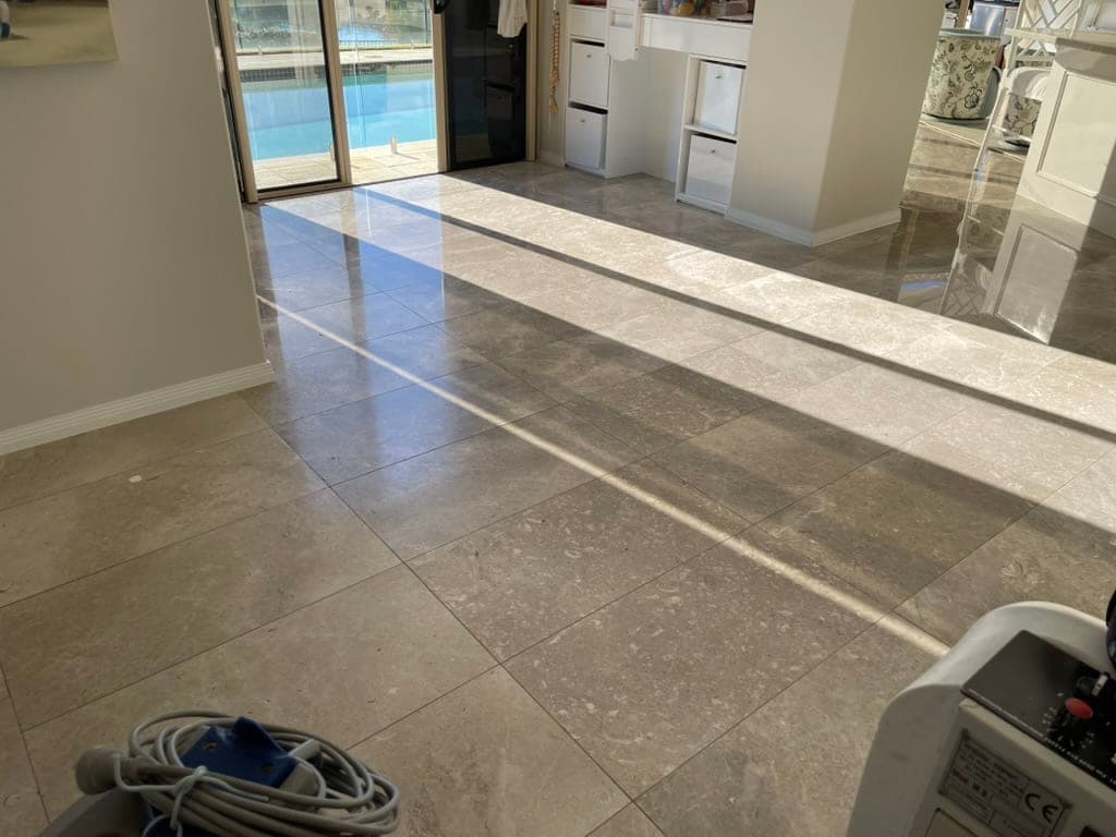 Grey marble floor leading toward the waterfront windows, cloudy and matte before restoration