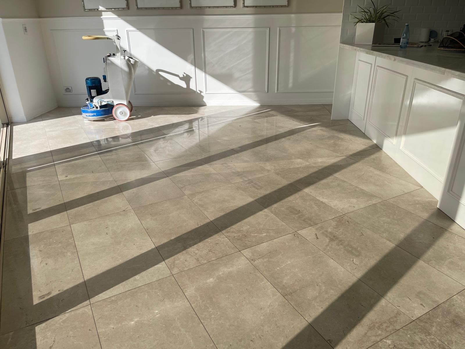 Grey marble dining-area floor before restoration, flat and worn beside the stone island bench