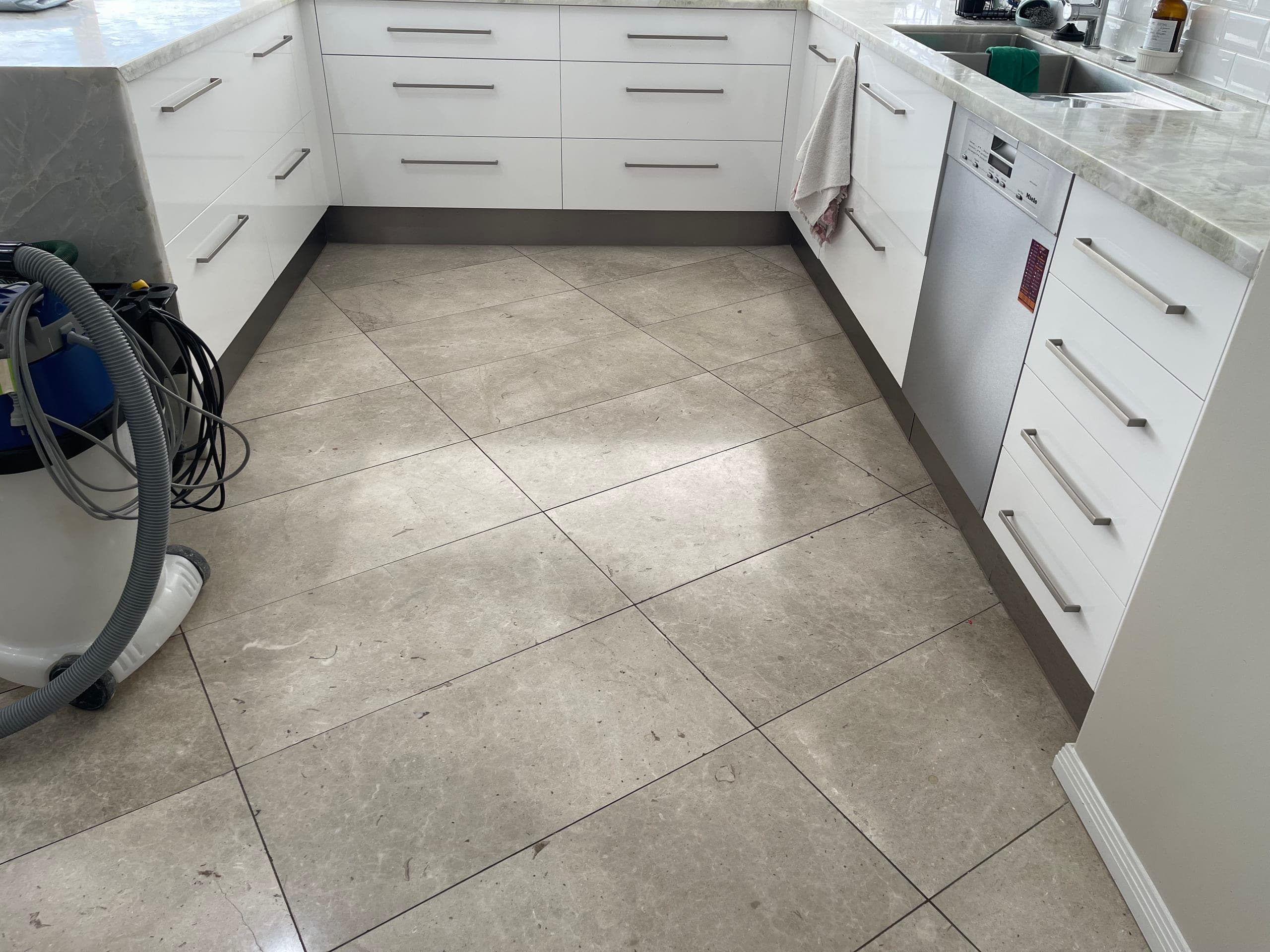 Grey marble kitchen floor before restoration, dull and matte